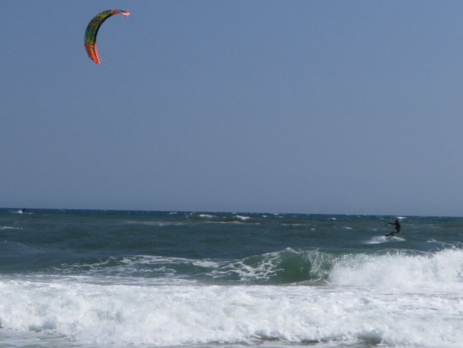 Kiteboarder mid-air over breaking waves at Cape Hatteras National Seashore on the Outer Banks