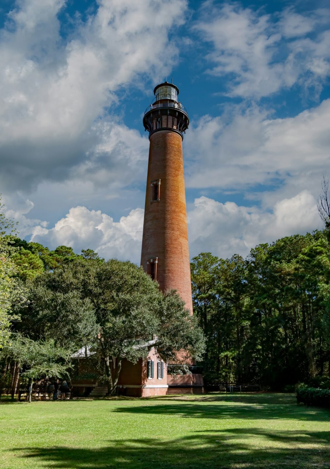 Currituck Beach Lighthouse standing tall on a lush green field in Corolla NC