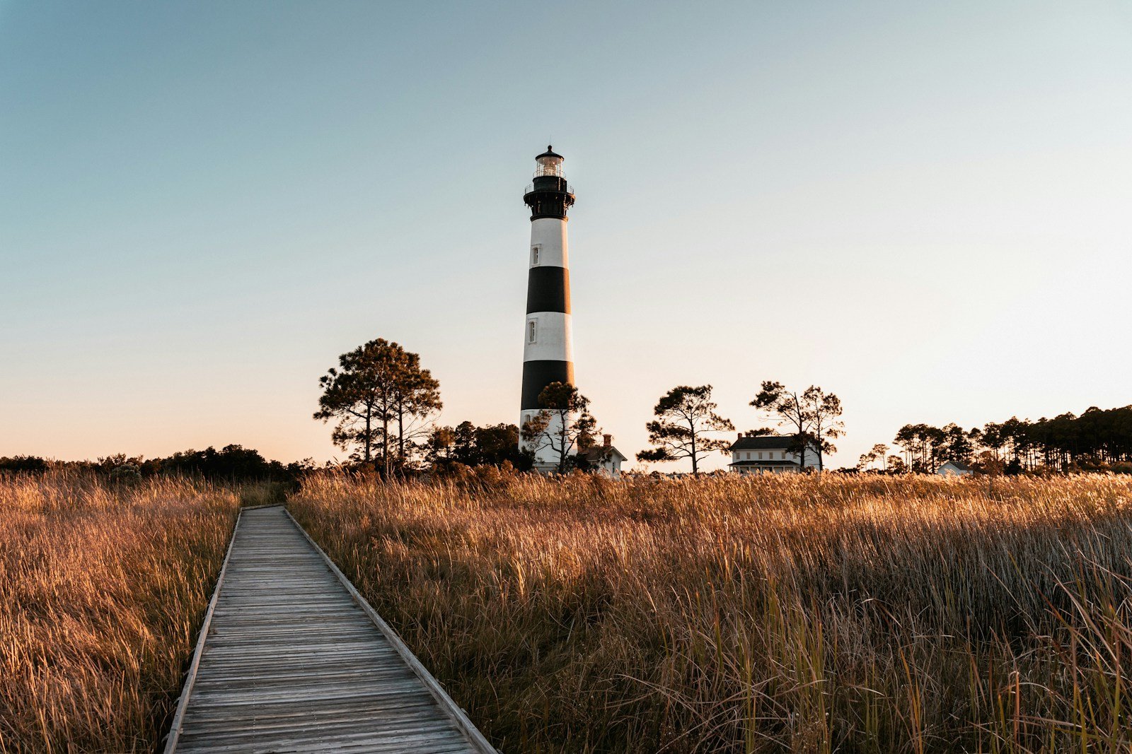 Bodie Island Lighthouse at sunset with boardwalk and tall marsh grass, Outer Banks NC