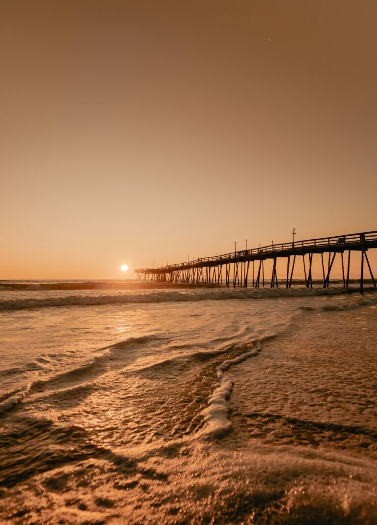 Wooden sound-side dock extending into calm water at sunset, Outer Banks