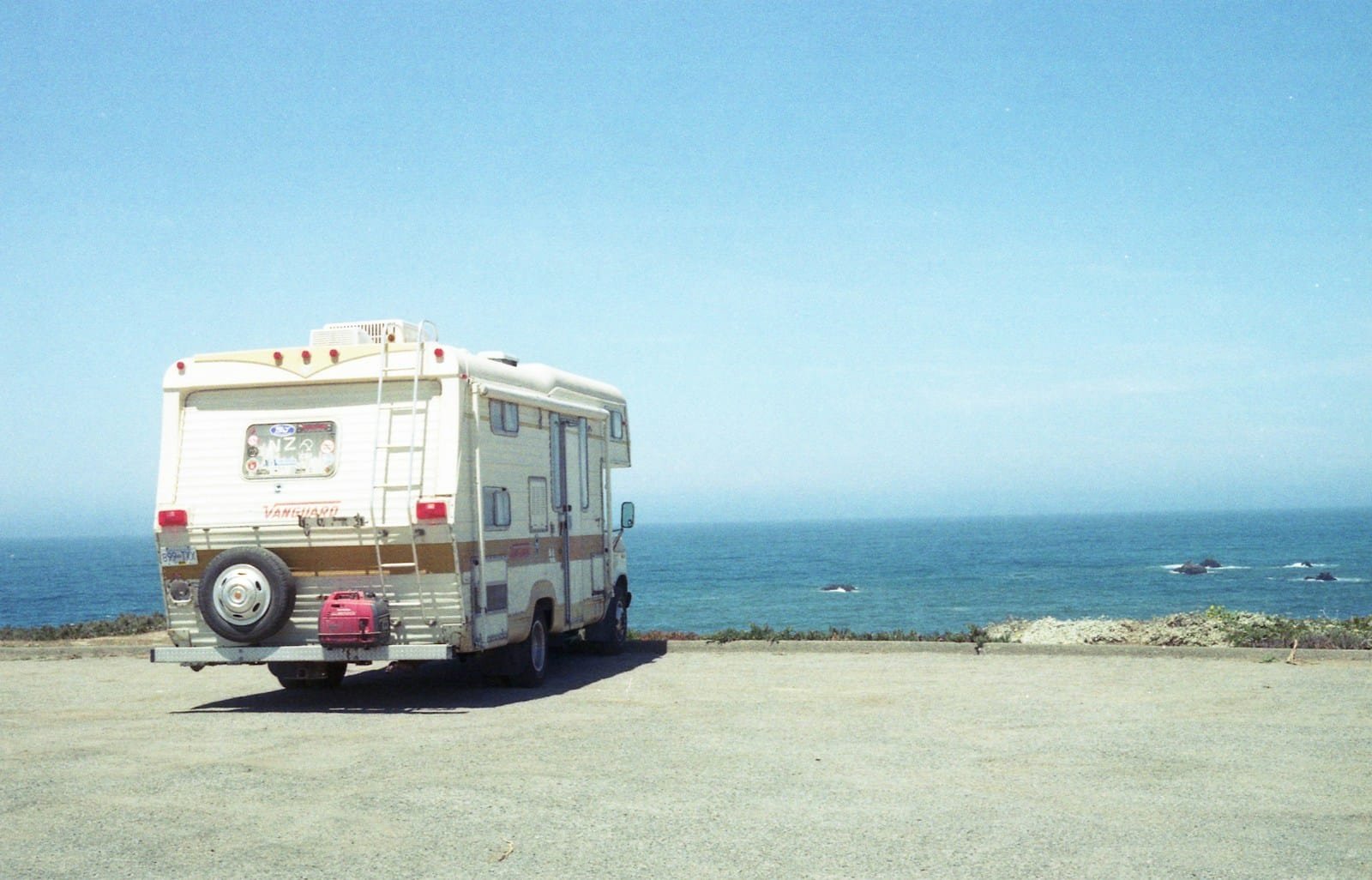 Camper van parked on a sandy beach during daytime