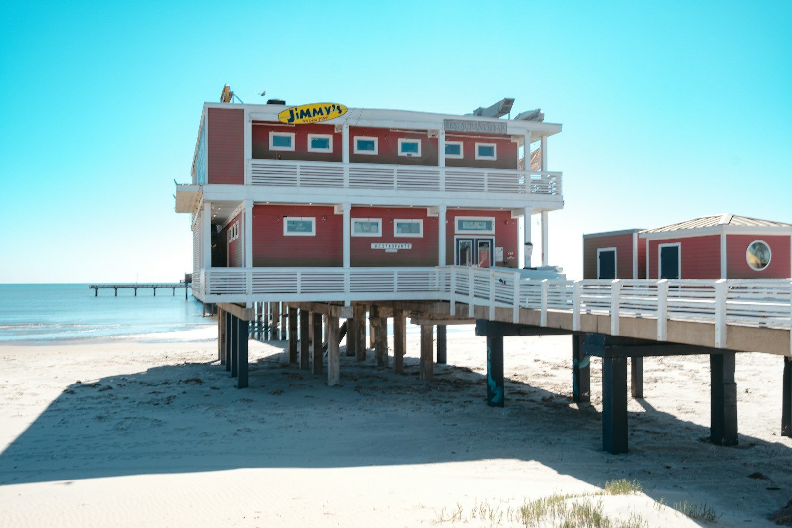 Red coastal restaurant on stilts at the beach