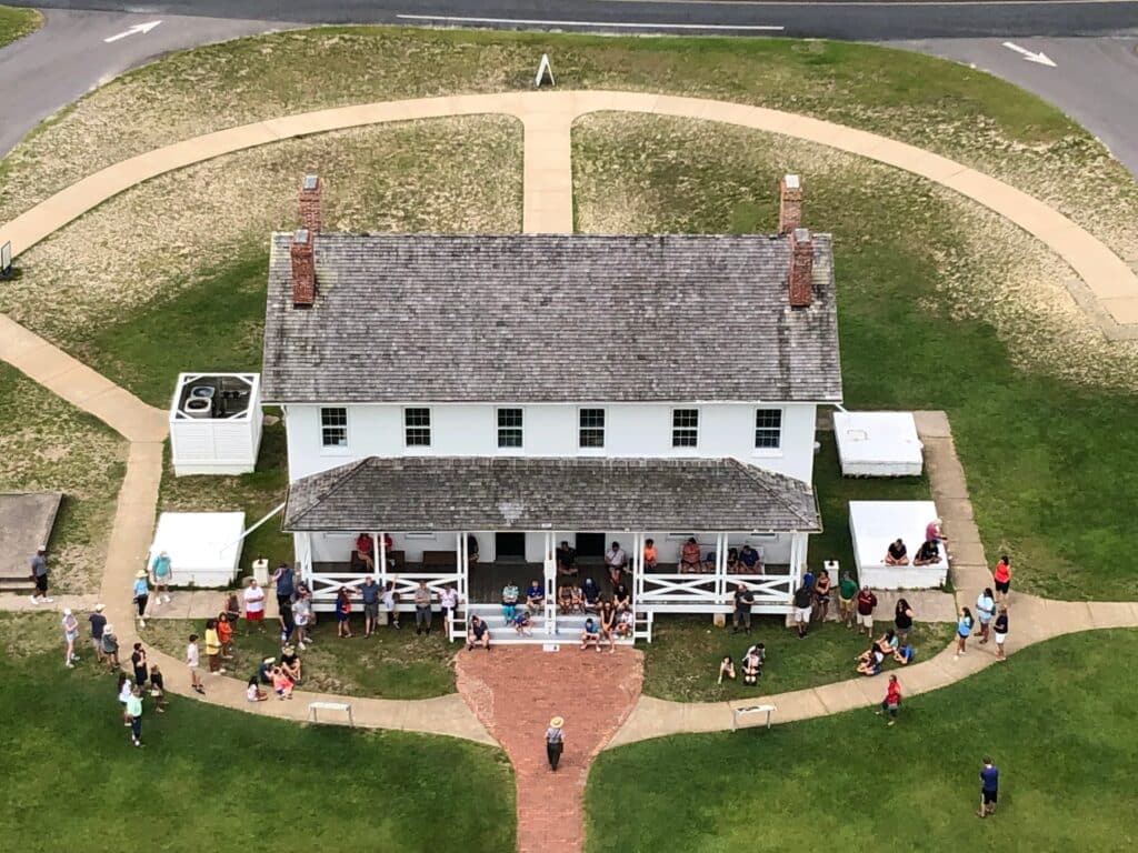 An elevated view over the Bodie Island Double Keepers Quarters and lawn with visitors gathered outside.