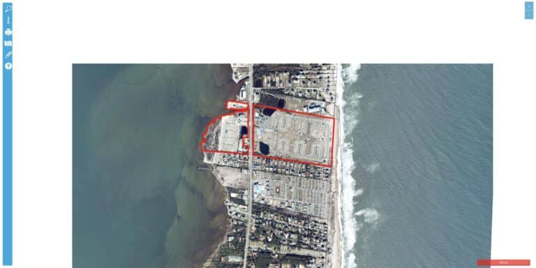 Aerial view of Camp Hatteras RV Resort, a sound-to-sea RV park at 24798 NC Highway 12 in Waves, North Carolina, stretching from Pamlico Sound to the Atlantic Ocean with hundreds of RV sites and pools.