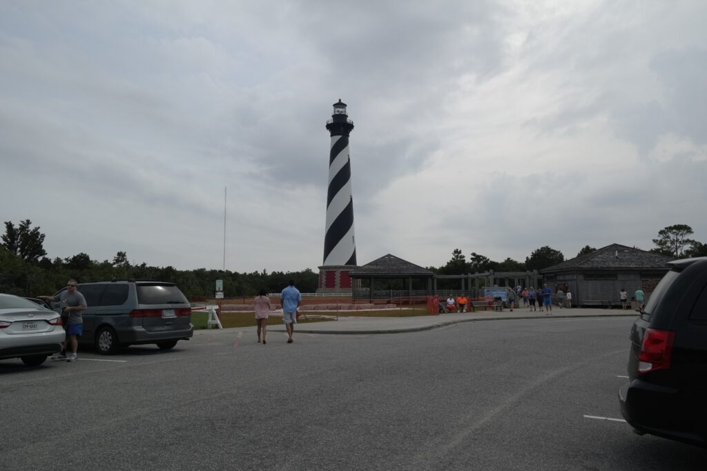 The black-and-white spiral-striped Cape Hatteras Lighthouse seen from the visitor parking area.