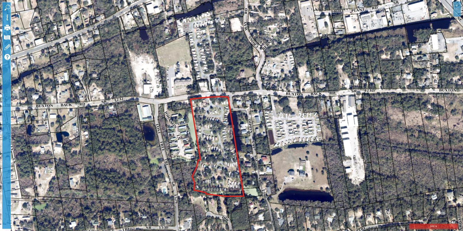 Aerial view of Cape Woods Campground in Buxton, NC, showing RV and camper sites set among maritime forest with the parcel boundary outlined