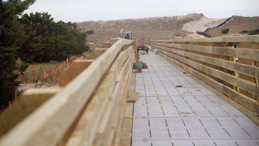 A long wooden boardwalk running over the dune line toward the beach at Ramp 25.
