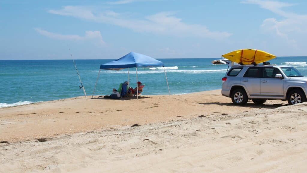 Beach umbrellas and canopies set up on the sand with the ocean beyond at Cape Hatteras National Seashore.