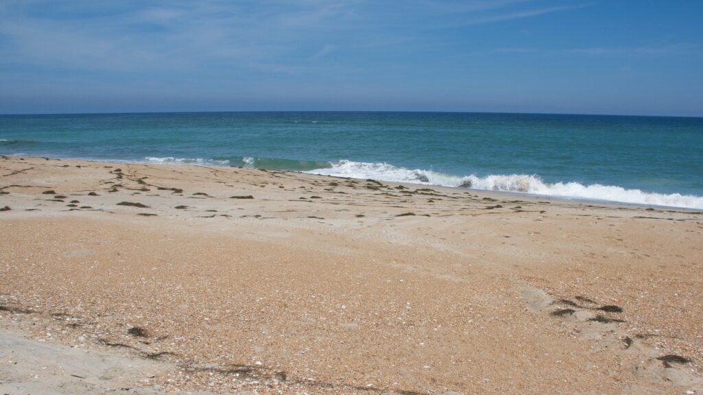 A wide, empty beach with calm surf and no one in sight at Cape Hatteras National Seashore.