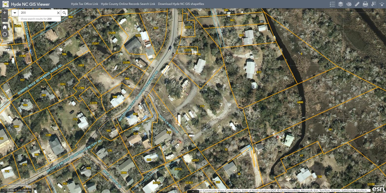 Aerial view of Teeter’s Campground on British Cemetery Road in Ocracoke village NC, showing campsites surrounded by maritime forest and tidal creeks