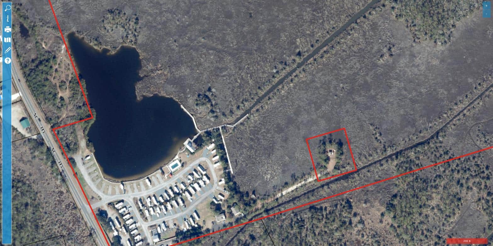 Aerial view of The Refuge on Roanoke Island RV park in Wanchese, showing waterfront RV sites arranged around a lagoon