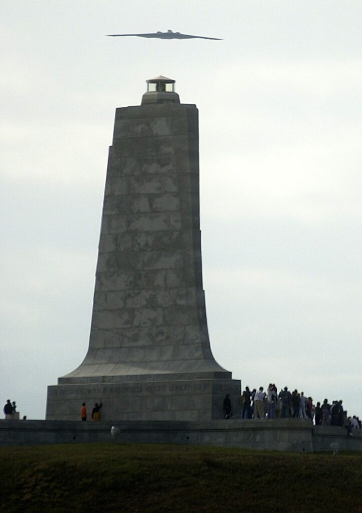 The tall granite pylon of the Wright Brothers National Memorial monument seen from below.